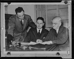 Three men at a desk