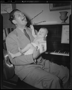 Man holding baby at piano