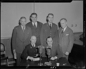 Six men posing behind W34B and WAAB microphones