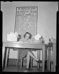 Woman sitting at desk in the Boston Opera Association office