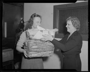 Woman handing off basket of papers in the Boston Opera Association office