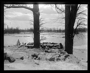 Snow covered rocks by a frozen pond