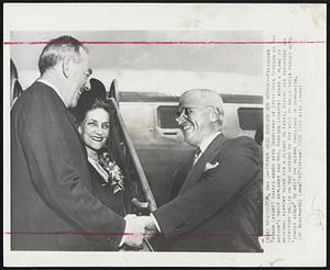 Truman Bids Acheson Bon Voyage--President Truman (right) shakes hands with Secretary of State Dean Acheson as the nation's chief diplomat and Mrs. Acheson (center) board plane at National Airport today for a flight to Paris. Before his departure the secretary called on the nations of the west to rally their forces with "utmost vigor" to meet the global challenge of communism.