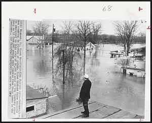 Overlooking Flooded Area--Unidentified man standing on rooftop of garage. Mayor Richard Maier declared an emergency in this city of 20,000 today as the Sandusky river rose to 15 feet. 500 people were removed from their homes in the lowlands.
