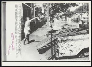 Scottsville, Va. -- Mud Galore -- One of the volunteers helping Scottsville clean debris out of its stores and streets tosses rubbish into a truck. Mud fills the town’s main street, which was flooded several feet deep by torrential pain earlier in the week. Weather Hurricane Camille.