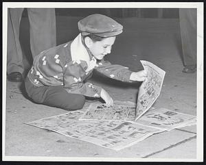Catching up-Six-year-old George L. Seltzer of Brookline stops at Park St. to read the Traveler and catch up up with what Dick Tracy has been doing. Today's Traveler brings the stories of many of your favorite comic strip characters up to date.