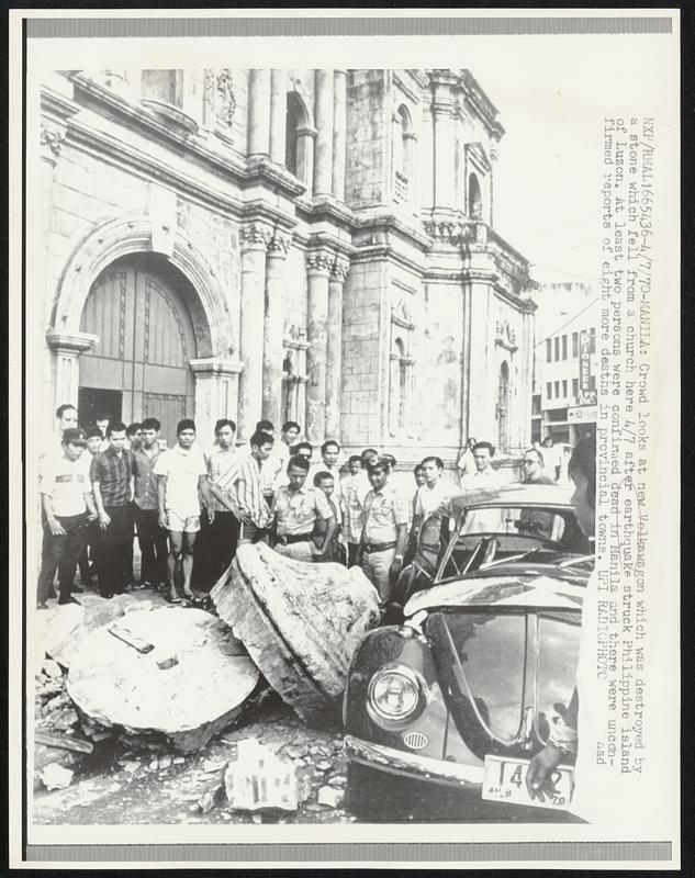 Crowd looks at new Volkswagon which was destroyed by a stone which fell from a church here 4/7 after earthquake struck Philippine island of Luzon. At least two persons were confirmed dead in Manila and there were confirmed reports of eight more deaths in provincial towns.\