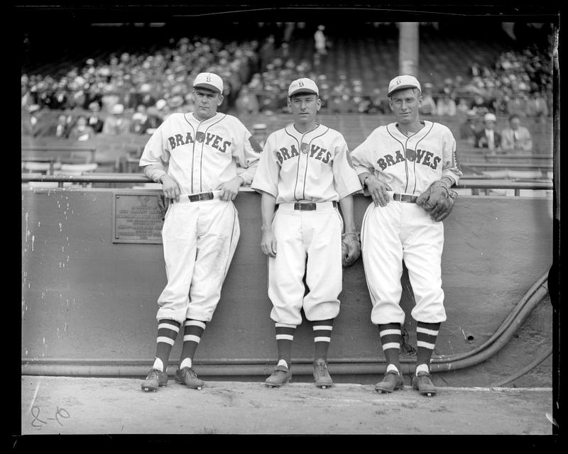 3 Braves lean aginst rail