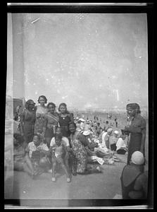 Nine women and children pose on a beach