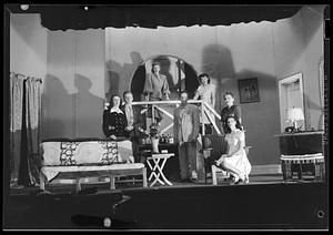 Five women and two men pose on a set