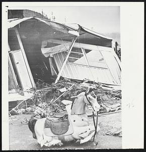 Residential area is gone. Below left, a lonely wooden hobby horse stands amid wreckage of trailer home