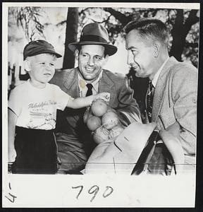 Phillies Get Big Welcome from 3 1/2-year-old George Sullivan, Jr., of Collingswood, N. J., who was on hand yesterday to welcome back the Phillies to their spring training camp at Clearwater, Fla. The youngster is presenting a bag of oranges to First Baseman Eddie Waitkus (right) and Outfielder Bill Nicholson.