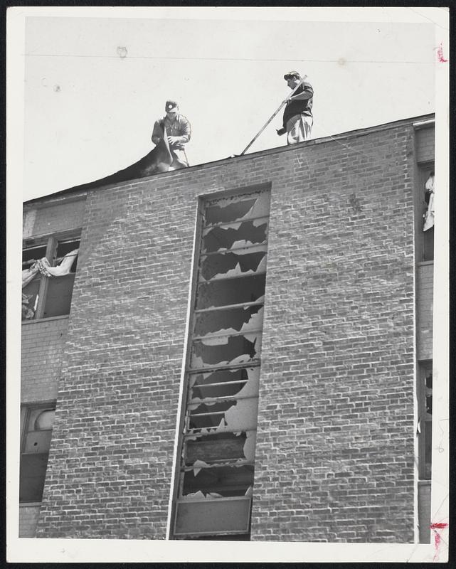 Roof Repairs are rushed on multiple living units hit by tornado. Here workmen are resealing the roof of the Great Brook Veterans Housing project, which when ready for occupancy will provide shelter for hundreds of the homeless.