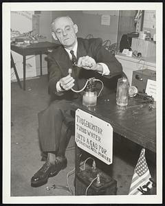 Inventors Display New Gadgets. Despite shortage of raw materials, there's no dearth of new inventions. Indeed wartime priorities have turned inventors to the creation of gadgets which circumvent priorities, if the 1942 Inventors' Exposition, sponsored by the American Hobby Federation in Sachs Auditorium is any indication. Here, for example, is Anthony Morch of New York City and his device for converting water into a gas for operating automobiles. The gadget is the small glass jar on the table and is attached to the battery on the floor. Mr. Ickes may be interested in this!