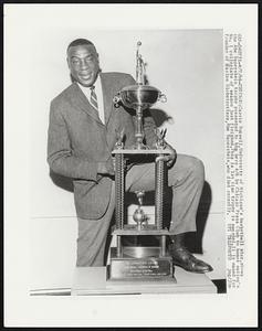 Cazzie Russell, University of Michigan’s basketball star, shows the Abe Saperstein trophy presented to him here 4/6 by Chicago Press Club to honor nation’s No. 1 collegiate of season just finished. This is 1st time trophy is awarded. It is named for founder of Harlem Globetrotters, Abe Saperstein, who died recently.