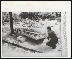 The Memory Won't Be Buried -- Man looks at caskets of his wife and daughter on sidewalk in Skopje, Yugoslavia, today before transportation arrived for burial at cemetery. Women and child were among victims of devastating earthquake last week.