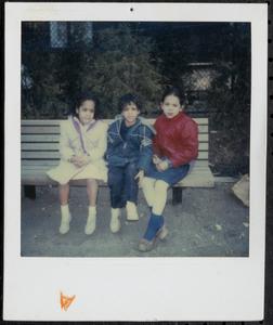 Three children sitting on a bench