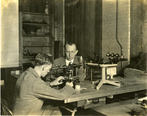 Dr. Edgar D. Tillyer at table with assistant working at American Optical Southbridge