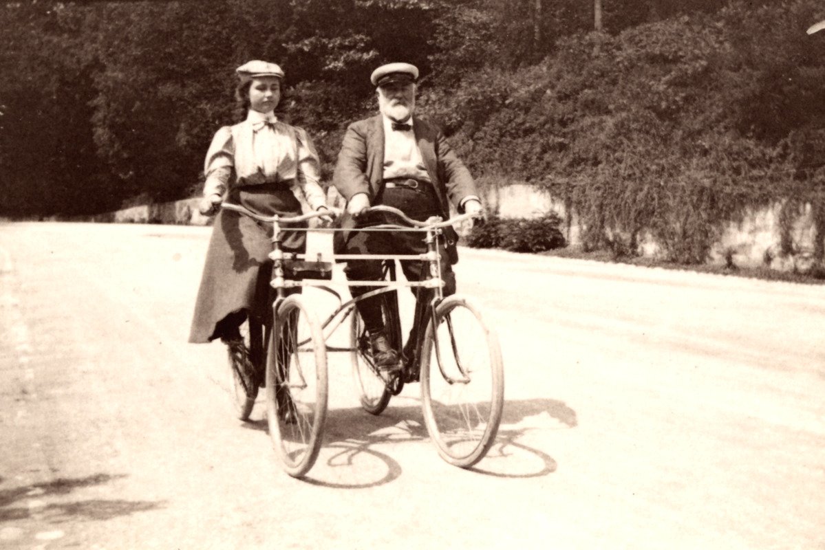 Elizabeth Robin and unidentified man riding a sociable bike