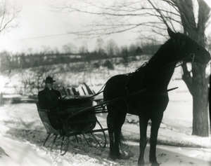 Bill McGuire in a horse-drawn sleigh