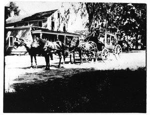 Stagecoach in front of store in center of town