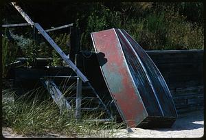 Small boat leaning against fence