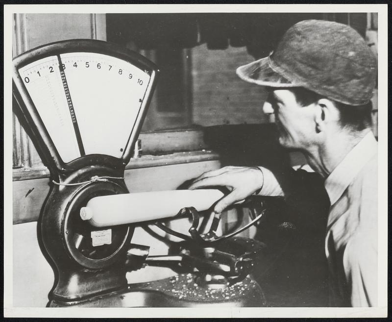 Cut down to size and shape, bat is weighed. When "ends" are cut off and bat is sanded, it will be the exact weight specified, generally about 32 ounces. (Photo at Hillerich and Bradsby Co. Louisville, Ky. plant.)