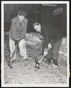 Tired of Waiting for the City to clear snow and ice-clogged Causeway street, a group of men with business establishments on the hired a private crew of workmen. Elmer Dick, left, and Reed attack the road block between Merrimack square and Leverett St.