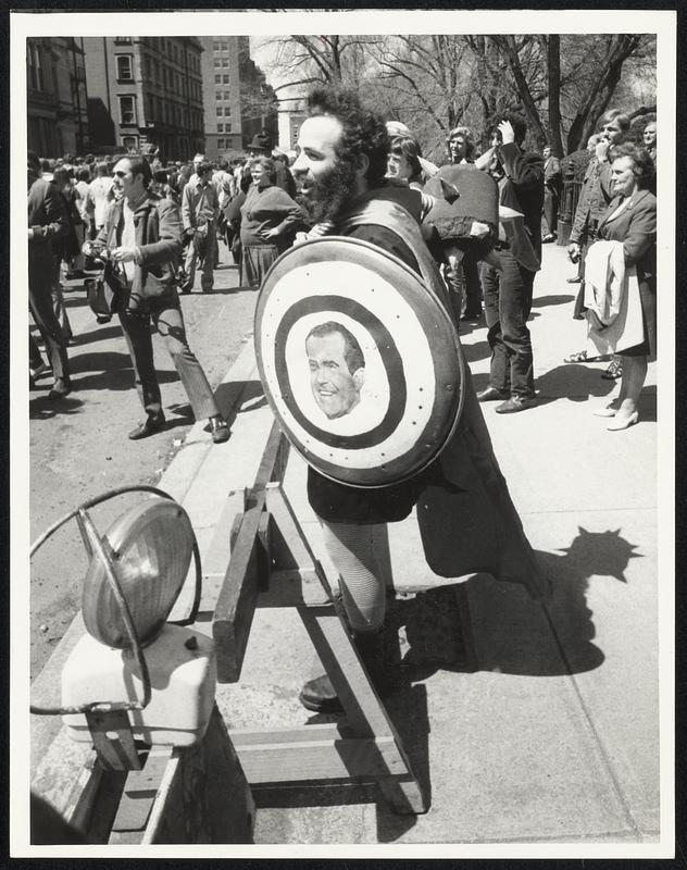 A Man Stands At A Barricade Holding A Shield Painted With A Picture Of ...