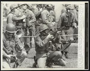 Wearing gas masks, National Guardsmen fire tear gas at Kent State University students which gathered on the commons. Several persons were reported killed and a number injured