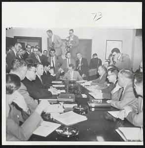 Negotiation Duel Starts--Representatives of General Motors and United Auto Workers start contract talks in Detroit. Walter P. Reuther, president of the union, is seated (fourth from left). Louis Seaton (fourth from right), seated., heads the General Motors negotiation staff. Newsmen crowd the room.