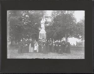 Group of women with flowers in front of Civil War monument