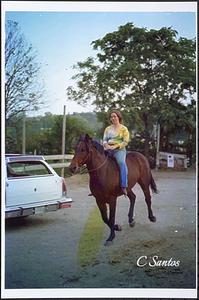 Jeany Mahoney riding her horse Clyde in front yard