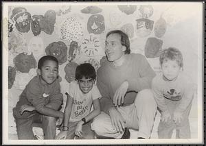 Man posing with three boys, including Damien on left