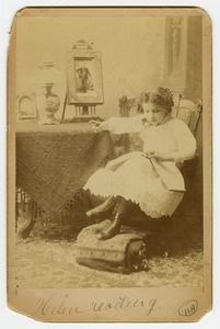 Helen Keller, as a young girl, reading