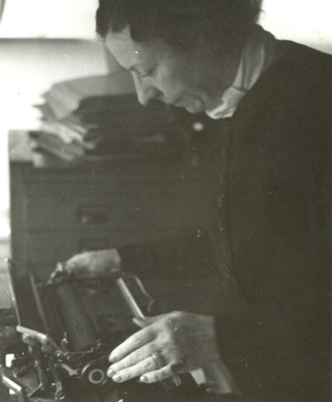 Polly Thomson Leaning over a Typewriter