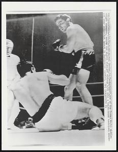 Marcel Cerdan, Jr. (background), son of the former World middle-weight champion, scores his eight straight victory 4/26 with a third-round technical knock-out over compatriot Robert Di Martine (on canvas).