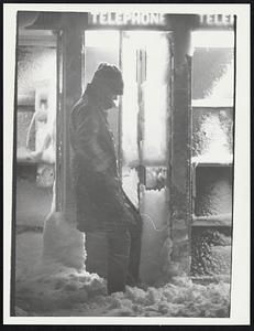 Man in show outside phone booth