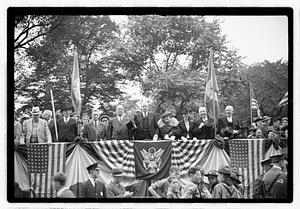 A group of people seated on a reviewing stand including Boston Parks Commissioner William Long