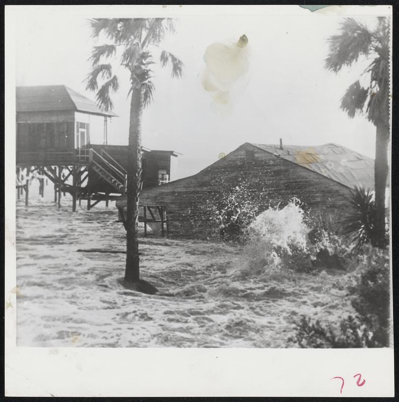 Beach House tumbles from its stilt-like support into the surf at Folly Beach, S. C. as waves lash waterfront during approach of Hurricane Diane.