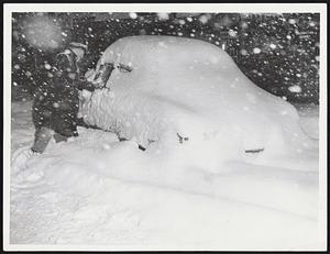 Stalled Car - This pile of snow is, as you can see by looking closely, an automobile. It was abandoned in the center of Stuart street near Park square when it became stuck. A taxi driver, Red Matthews, scrapes snow from a window to be sure there were no occupants.