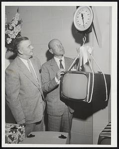 Weighing-In Ceremony finds Challenger, new Raytheon TV receiver, comfortably under 50 pounds. Officiating, Gardner Cole (left), vice president and general manager of the Boyd Corporation; and Charles F. Adams, president of Raytheon Manufacturing Corporation.