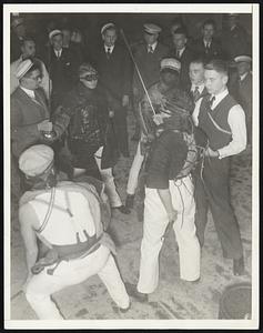 Ready for the Duel. Opponents face each other, their bodies protected by padding and their eyes by goggles. Referees, also protected, stand on either side. Notice the peculiar stance of the duelists. According to rules of the "sport" they must not take a backward step.