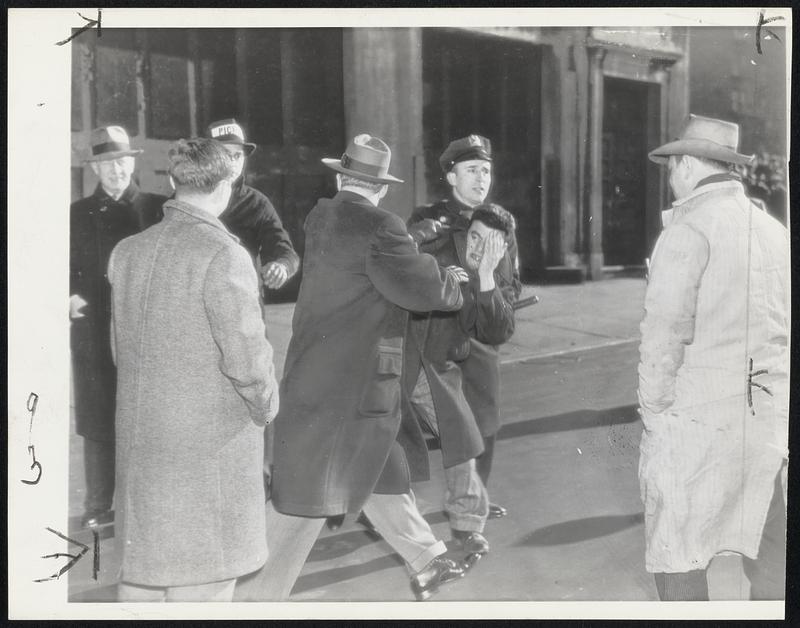 Picket Line Clash At Western Electric - William Santora, 27, a picket at the Western Electric plant in New York, is shown above being forcibly restrained by a policeman and a detective during a picket-line clash.