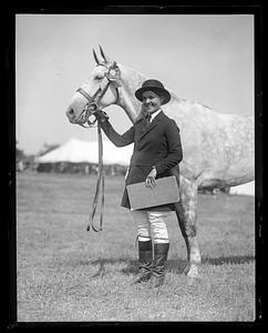 Unidentified woman holding the reins of a horse