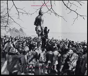 Indians and onlookers gather around statue of Massasoit to hear Russell Means