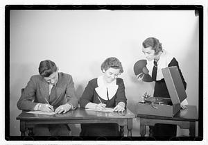 A man and a woman listening to a record, possibly taking a test
