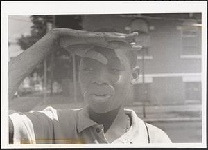 Young man shielding his eyes from the sun