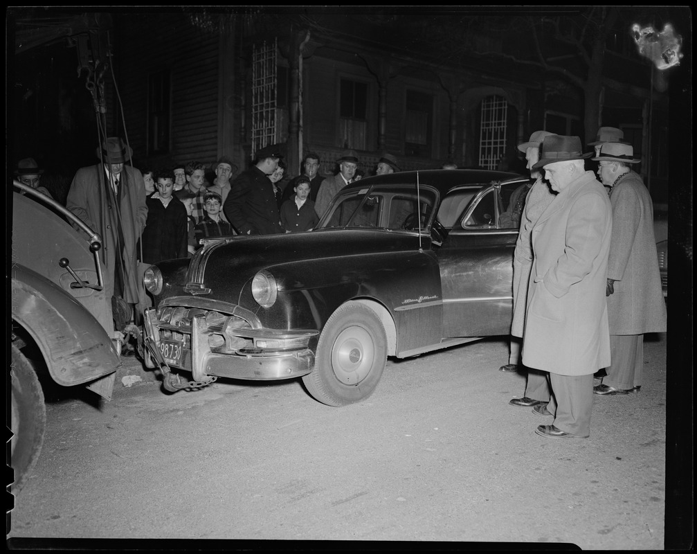 Men watching a tow truck take a vehicle