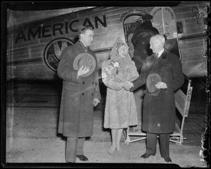 Sonja Henie greeted by two men after exiting the plane